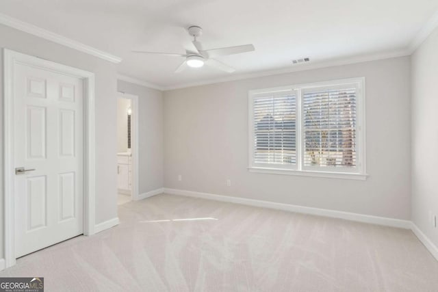 unfurnished bedroom with ceiling fan, ornamental molding, ensuite bathroom, and light carpet