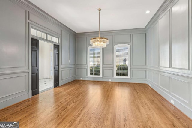 unfurnished dining area with light hardwood / wood-style floors and an inviting chandelier