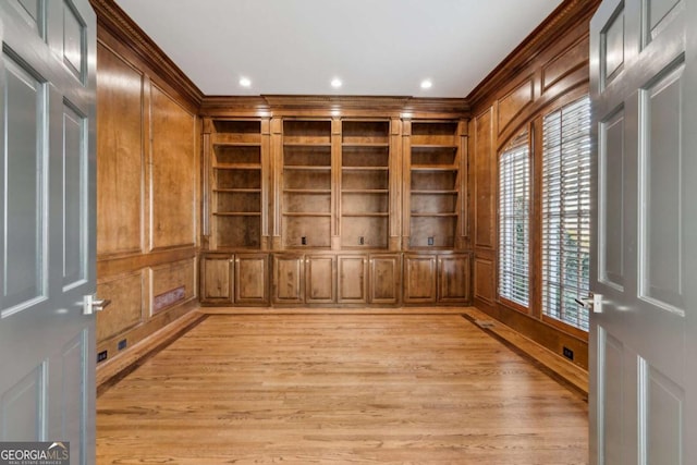 interior space with built in shelves, light hardwood / wood-style flooring, and ornamental molding