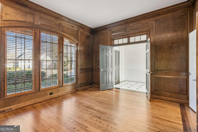 entryway featuring light wood-type flooring, plenty of natural light, and wooden walls