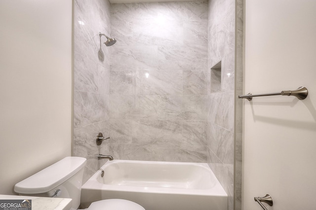 bathroom with toilet and tiled shower / bath