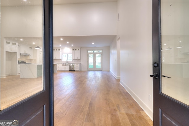 interior space featuring french doors, light hardwood / wood-style flooring, and sink