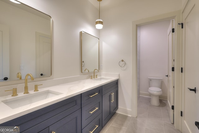 bathroom featuring toilet, vanity, and tile patterned floors