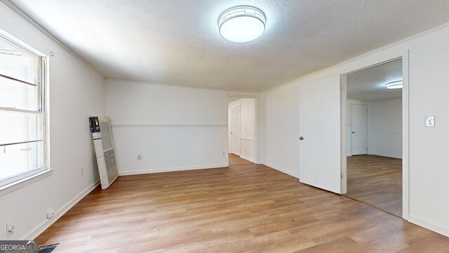 empty room featuring a textured ceiling and light hardwood / wood-style floors