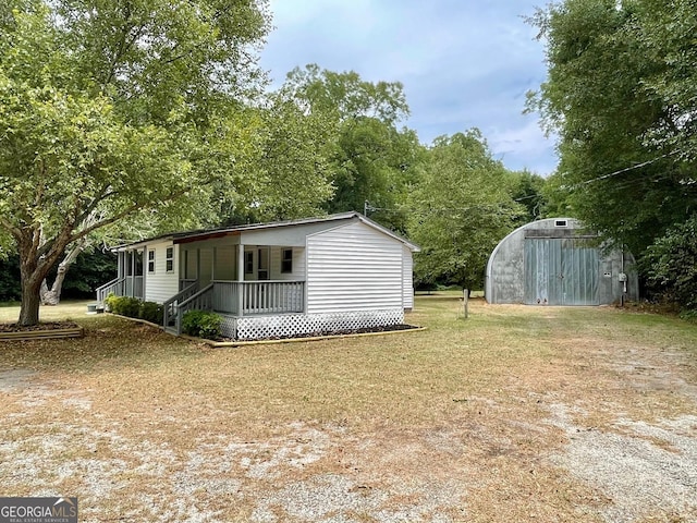 exterior space with a yard, an outbuilding, and covered porch