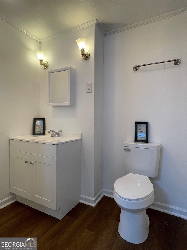 bathroom with hardwood / wood-style floors, vanity, toilet, and ornamental molding