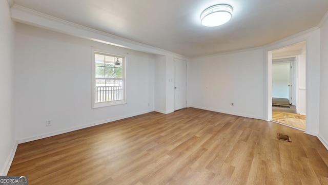 spare room featuring light hardwood / wood-style floors and crown molding