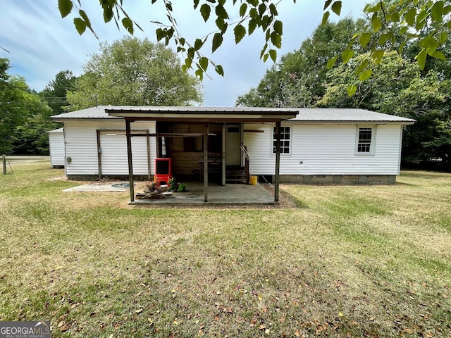 rear view of property featuring a lawn