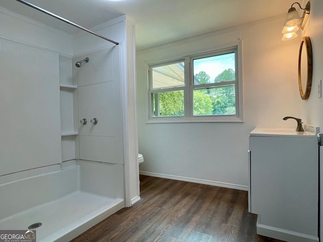 bathroom with hardwood / wood-style floors, vanity, toilet, and walk in shower