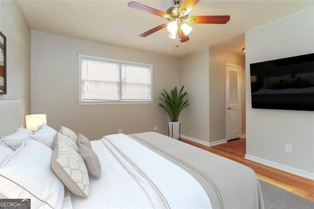 bedroom featuring ceiling fan, a closet, and light hardwood / wood-style floors