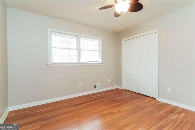 unfurnished bedroom with ceiling fan, a closet, and light hardwood / wood-style flooring