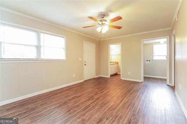 unfurnished bedroom with ceiling fan, ornamental molding, connected bathroom, and wood-type flooring