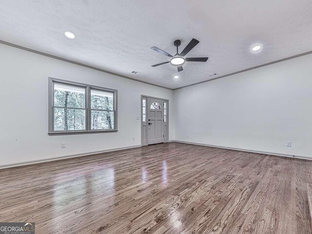 interior space featuring hardwood / wood-style flooring, ceiling fan, and crown molding