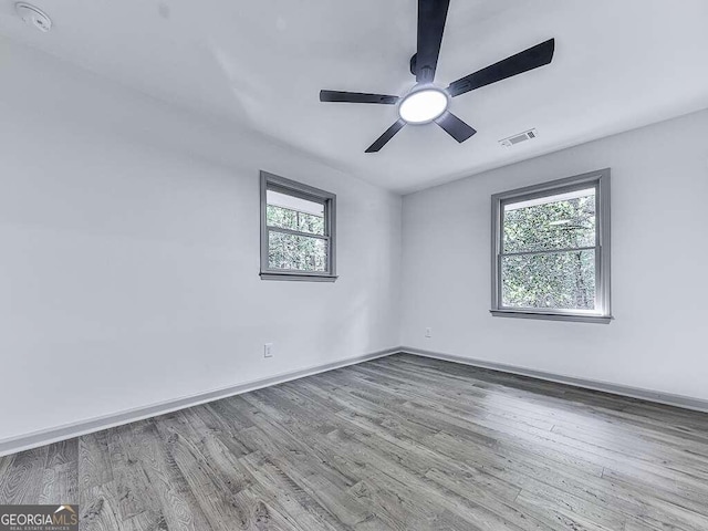 spare room with wood-type flooring, plenty of natural light, and ceiling fan