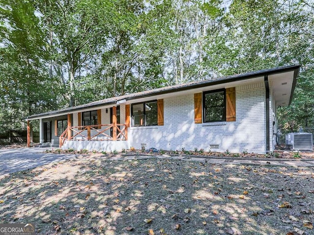 ranch-style house featuring covered porch and central air condition unit