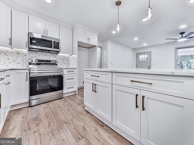 kitchen featuring white cabinets, appliances with stainless steel finishes, backsplash, and pendant lighting