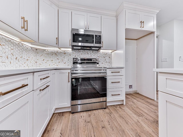 kitchen with tasteful backsplash, white cabinets, stainless steel appliances, and light hardwood / wood-style floors