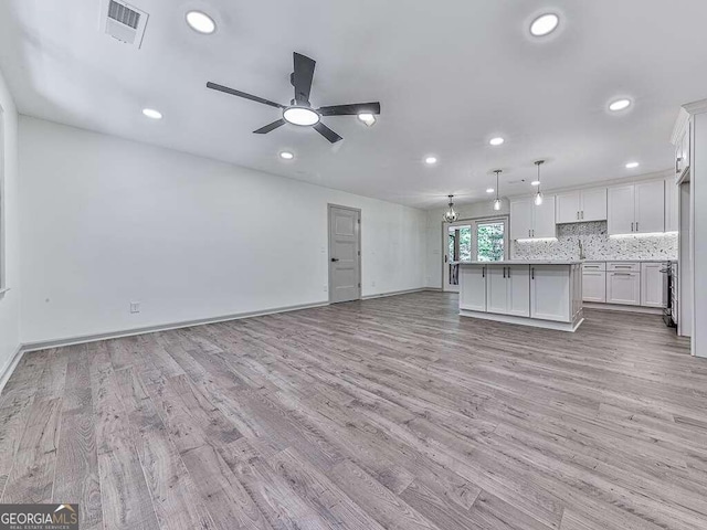 unfurnished living room with ceiling fan and light wood-type flooring