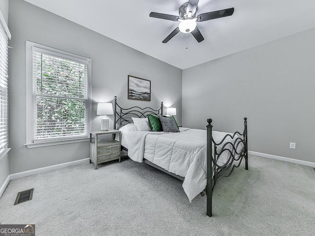 bedroom featuring multiple windows, ceiling fan, and carpet floors