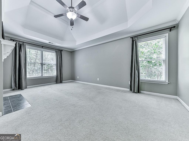 carpeted empty room featuring a tray ceiling, ceiling fan, and ornamental molding