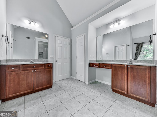 bathroom featuring tile patterned flooring, vanity, and vaulted ceiling