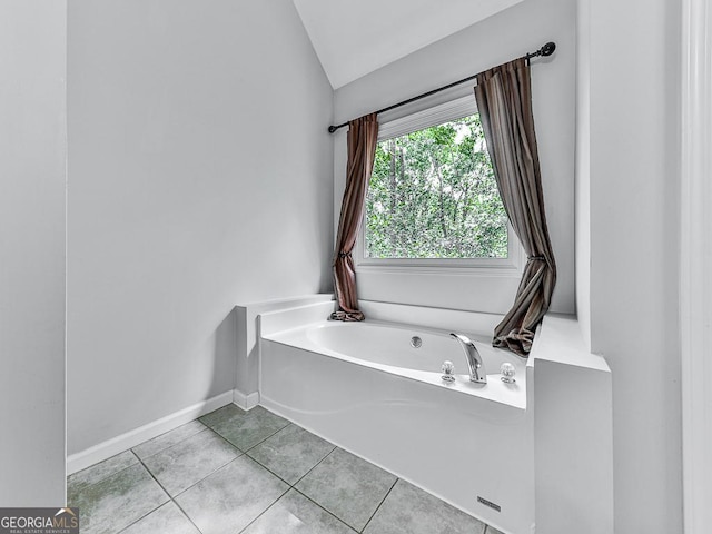 bathroom with tile patterned flooring, vaulted ceiling, and a bathtub