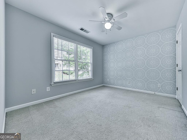 carpeted spare room featuring ceiling fan