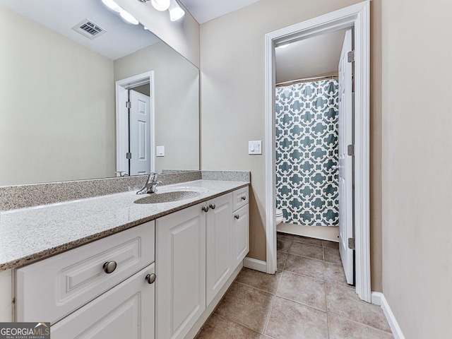 bathroom with tile patterned flooring, vanity, and toilet