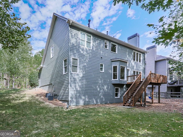 back of property featuring a yard, a wooden deck, and central air condition unit