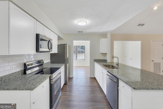 kitchen featuring decorative backsplash, stainless steel appliances, sink, stone counters, and white cabinets