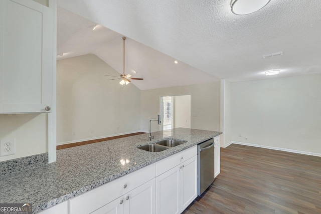 kitchen featuring light stone counters, stainless steel dishwasher, white cabinetry, and sink