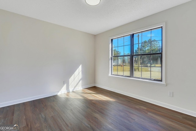 unfurnished room featuring a textured ceiling and dark wood-type flooring