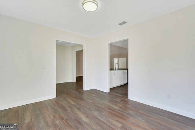 empty room with dark hardwood / wood-style flooring and sink