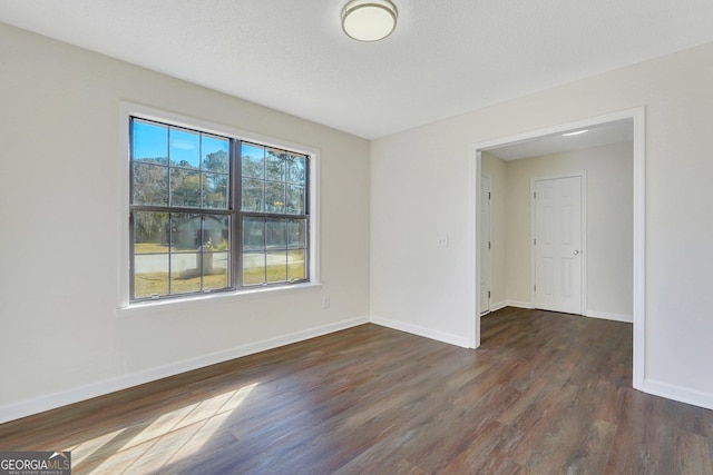 spare room with dark hardwood / wood-style flooring and a textured ceiling