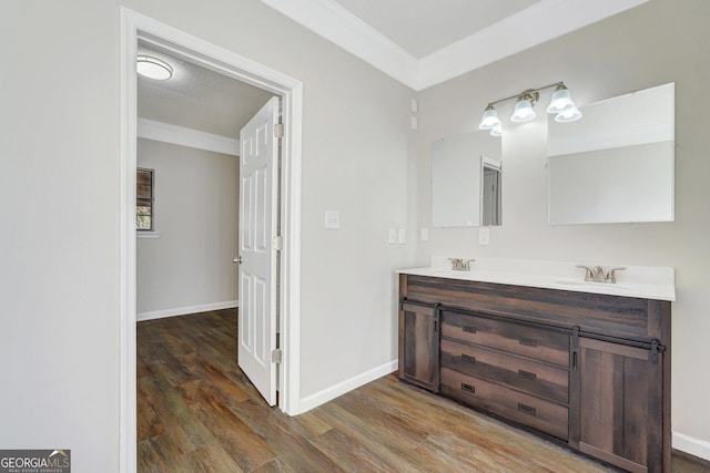 bathroom featuring vanity, wood-type flooring, a textured ceiling, and ornamental molding