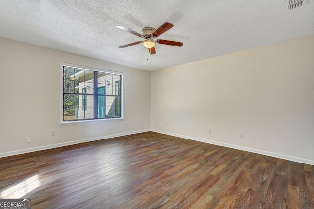 empty room featuring a textured ceiling, dark hardwood / wood-style floors, and ceiling fan