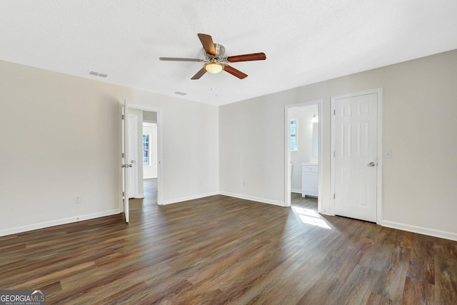 unfurnished room with a textured ceiling, ceiling fan, and dark wood-type flooring