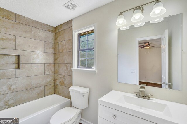 full bathroom featuring ceiling fan, a textured ceiling, toilet, vanity, and tiled shower / bath