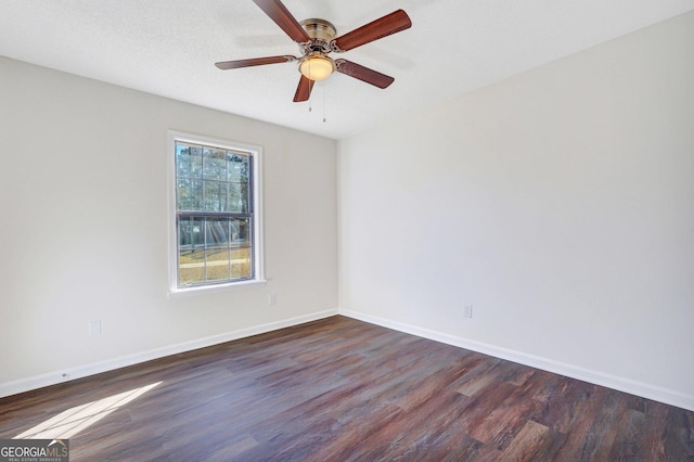 empty room with dark hardwood / wood-style floors and ceiling fan