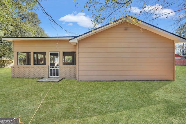 rear view of house featuring a lawn