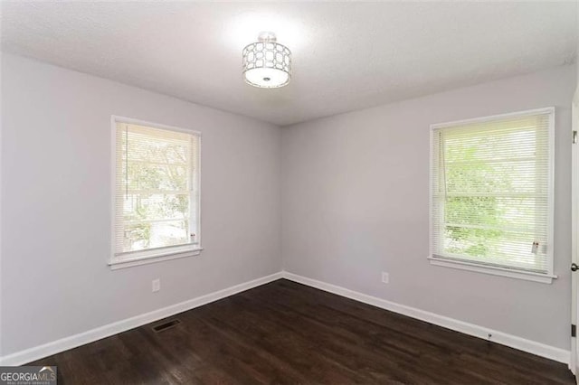 unfurnished room featuring dark wood-type flooring