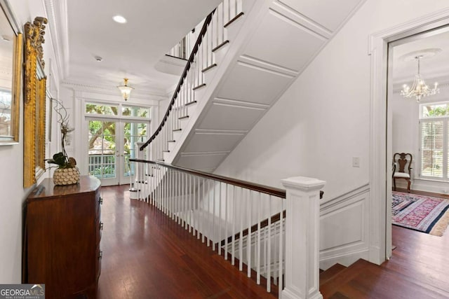 staircase with an inviting chandelier, wood-type flooring, a wealth of natural light, and french doors