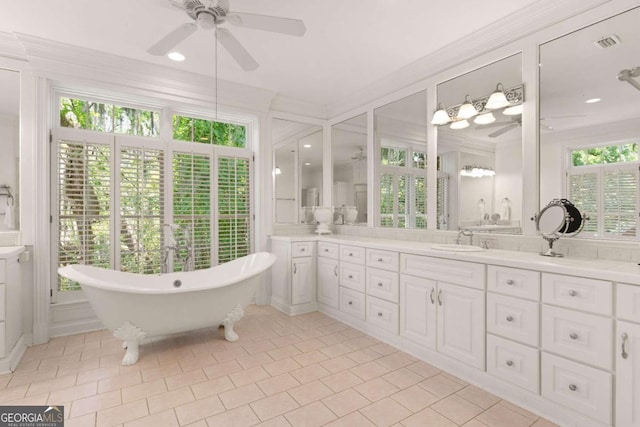 bathroom with tile patterned floors, a washtub, vanity, ceiling fan, and crown molding