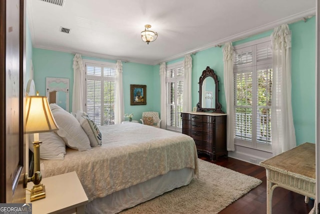 bedroom with dark hardwood / wood-style floors and ornamental molding