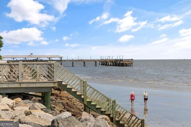 dock area with a water view and a beach view