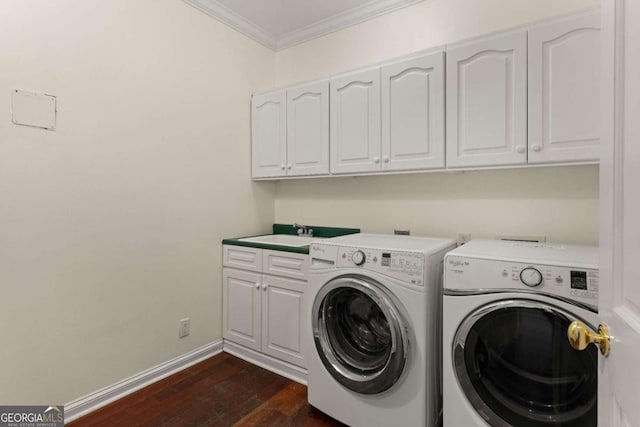 laundry room with cabinets, dark wood-type flooring, sink, ornamental molding, and washing machine and clothes dryer