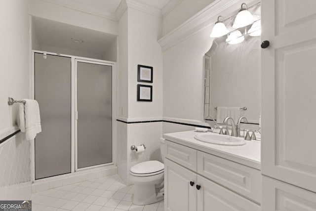 bathroom featuring tile patterned floors, vanity, a shower with shower door, tile walls, and ornamental molding