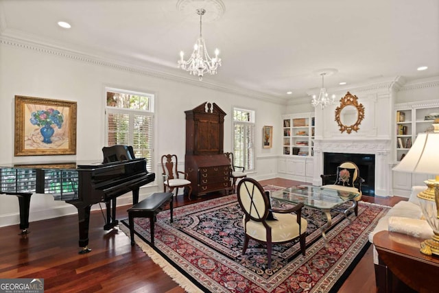 living room with built in shelves, dark hardwood / wood-style flooring, an inviting chandelier, and ornamental molding