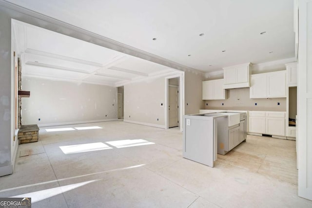 kitchen featuring white cabinets, a center island, and beamed ceiling