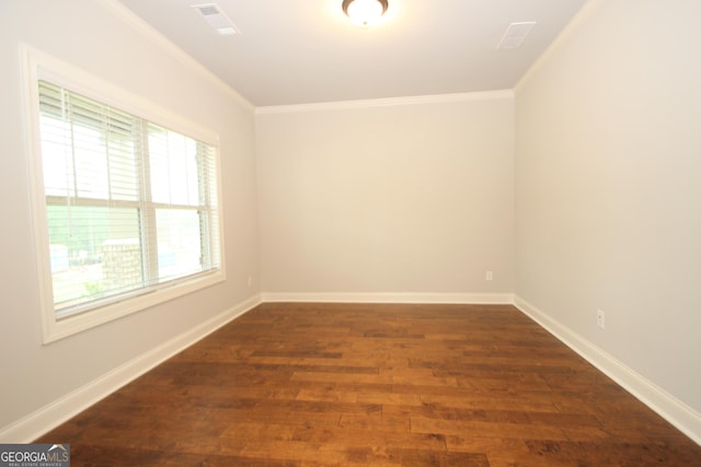 spare room featuring dark hardwood / wood-style flooring and crown molding